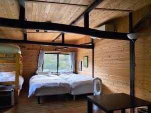 a bedroom with two beds in a wooden cabin at Sakura House サクラハウス 高知駅から車で20分-豊かな自然を味わう山の隠れ家 in Kochi