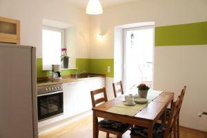 eine Küche mit einem Holztisch und eine Küche mit grünen Wänden in der Unterkunft Weingut Loescher in Senheim