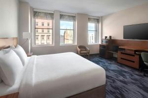 a hotel room with a white bed and a desk at Fairfield Inn & Suites by Marriott Albany Downtown in Albany +20 photos