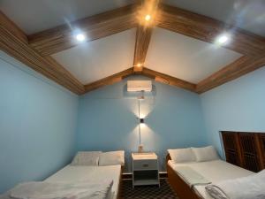 a room with two beds and a ceiling with lights at Hotel Dobhan in Bharatpur