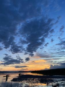a sunset over a body of water with clouds at Hotel Dobhan in Bharatpur