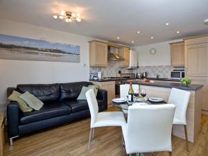 a living room and kitchen with a couch and a table at 1 Harbour View in Newquay