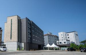 Kyŏngp'o-malにあるAJ Hotelの一部の建物の隣の駐車場内の建物