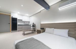 Kyŏngp'o-malにあるAJ Hotelの大きなベッドとキッチンのある寝室