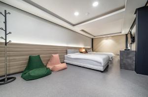 Kyŏngp'o-malにあるAJ Hotelのベッドルーム1室(ベッド1台、緑の椅子2脚付) +29枚の写真