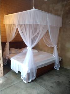 a bed with a canopy in a room at Muthu Villa in Mirissa