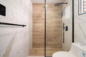 a shower with a glass door in a bathroom at 2bedroom Lux house Isla Verde with Private Patio by PH in Carolina +15 photos