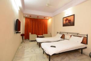 una camera d'albergo con due letti e una televisione di Hotel Vrandavan a Nagpur