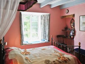 ein Schlafzimmer mit einem Bett und einem Fenster in der Unterkunft Felicity Cottage in Staithes