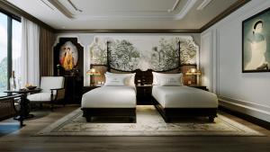 1 Schlafzimmer mit 2 Betten, einem Tisch und einem Gemälde in der Unterkunft L'amour Cruise Halong 2 in Hạ Long