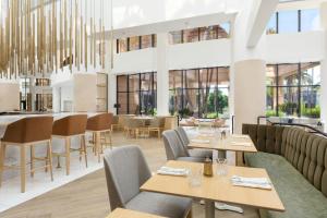 a restaurant with tables and chairs and windows at The Westin Long Beach in Long Beach