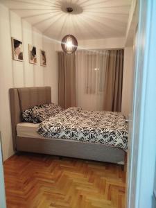 ein Schlafzimmer mit einem Bett mit einer schwarz-weißen Bettdecke in der Unterkunft Apartment Angeleski in Bitola