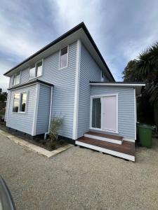 a white house with a porch and a porch at Top of Tyne - Peace, Comfort & Local Connection in Oamaru