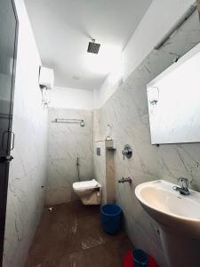 Un baño blanco con lavabo e inodoro. en Xylem Sea Side Resort, en Puri