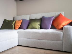 a white couch in a living room with pillows at Apartamenty Białystok - Marii Skłodowskiej-Curie 6 in Białystok