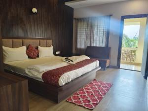 Un dormitorio con una cama grande y una ventana. en Xylem Sea Side Resort, en Puri