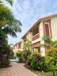 Un edificio con una pasarela de ladrillos al lado de un complejo turístico. en Xylem Sea Side Resort, en Puri