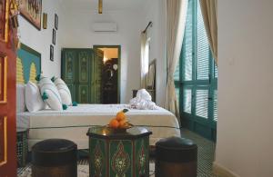 a bedroom with a bed and two stools in it at Riad Dar Hamid Hotel & Spa in Marrakech +48 photos