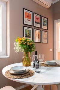 a dining room table with plates and a vase of flowers at Casa KAI Ostia in Lido di Ostia