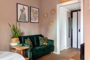 a green couch in a room with a bedroom at Casa KAI Ostia in Lido di Ostia