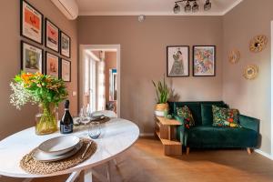 a living room with a table and a green couch at Casa KAI Ostia in Lido di Ostia