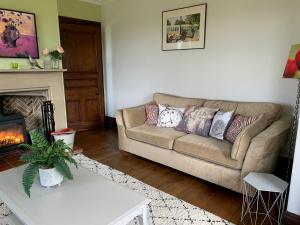 een woonkamer met een bank en een open haard bij Eversfield in Goathland +44 foto's