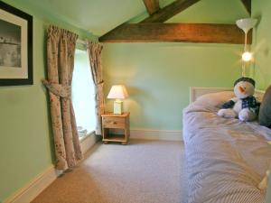 een teddybeer op een bed in een slaapkamer bij The Old Stables in Helsby