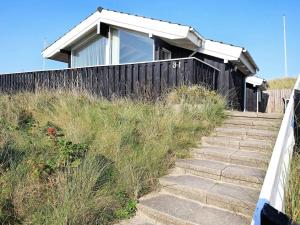 a house on top of a hill with stairs at 6 person holiday home in Løkken-By Traum in Løkken