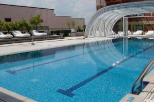 a large swimming pool with blue water in a building at Madrid Marriott Auditorium Hotel & Conference Center in Madrid +84 photos