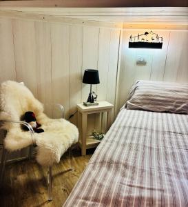 een slaapkamer met een bed en een stoel naast een bed bij Frazione Breuil Cervinia in Breuil-Cervinia