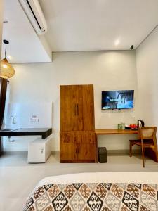 金巴兰Baliem Resort Jimbaran的一间卧室配有木制橱柜和一张书桌 更多74张照片
