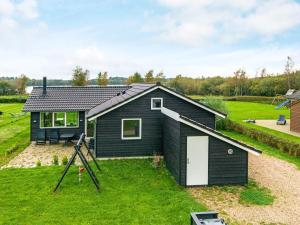 een klein zwart huis op een grasveld bij 10 person holiday home in Ansager in Ansager