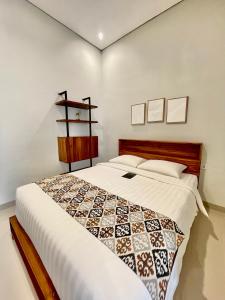 金巴兰Baliem Resort Jimbaran的一间卧室，床上铺着被子