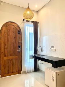 金巴兰Baliem Resort Jimbaran的厨房设有黑色柜台和木门。