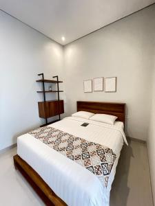 金巴兰Baliem Resort Jimbaran的卧室里有一张铺着白色床单的大床