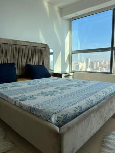 a large bed in a room with a large window at Appartement haut standing a mobilart in Oran