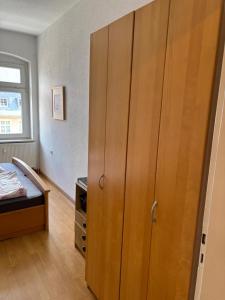 een slaapkamer met een grote houten kast en een bed bij Lindenstraße in Aue-Bad Schlema