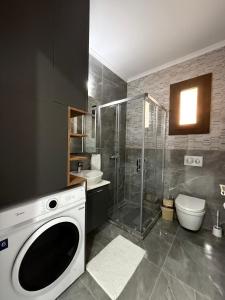 a bathroom with a shower and a washing machine at Riverside Life Residence in Iskele