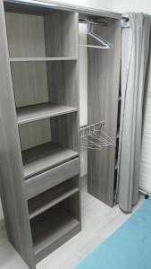 a brown closet with shelves and a curtain at T2 refait à Neuf au calme avec TV et Fibre in Craponne +1 photo