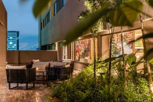 an outdoor patio with chairs and tables on a building at Fairfield by Marriott Medellin Sabaneta in Medellín