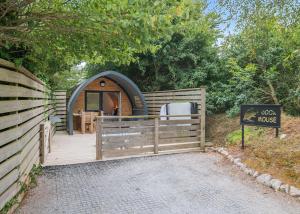 ein kleines Haus mit einem Holzzaun und einem Schild in der Unterkunft Henfields Country Retreat in Otterhampton