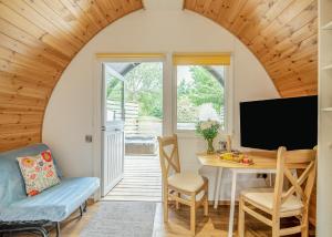 ein Wohnzimmer mit Tisch und Fernseher in der Unterkunft Henfields Country Retreat in Otterhampton + 66 Fotos