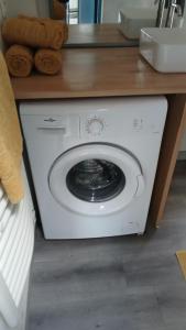 a white washing machine sitting under a counter at T2 refait à Neuf au calme avec TV et Fibre in Craponne