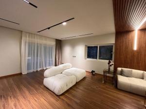 - un salon avec deux canapés blancs et deux chaises dans l'établissement Velora 4 BR Villa With pool and waterfall in New Cairo, au Caire