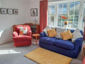 a living room with a blue couch and a red chair at Peel Wyke in Keswick