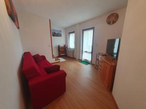 Conveniente, tranquilla con parcheggio في بيلونو: غرفة معيشة بها أريكة حمراء وتلفزيون