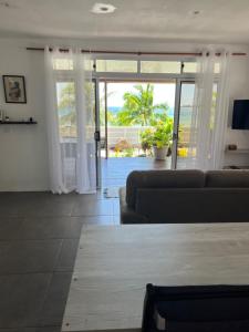 a living room with a couch and a view of the ocean at Blue Essence Tahaa in Tahaa