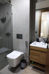 达布阿扎Dar Bouazza Luxury apartment with pools garden sports courts parking near the sea的浴室里有马桶、洗手池和淋浴。 更多11张照片