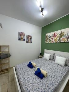 a bedroom with a bed with blue pillows on it at Sicilia Bedda Casa Vacanze in Lascari