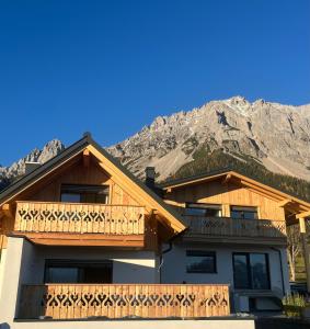 a house with a balcony with mountains in the background at Ferienhaus Korda in Ramsau am Dachstein